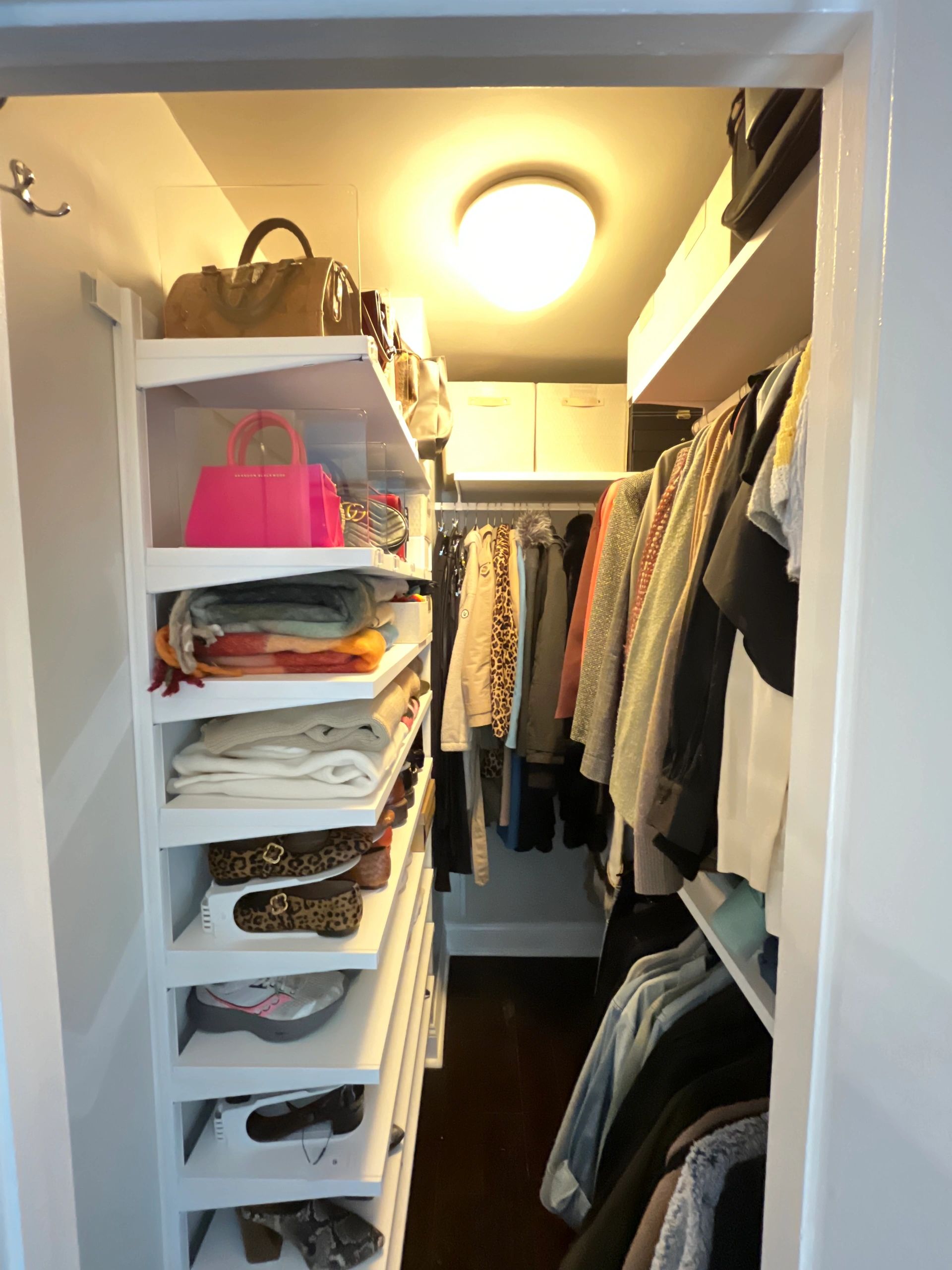 Walk-in closet with white shelving and handbags