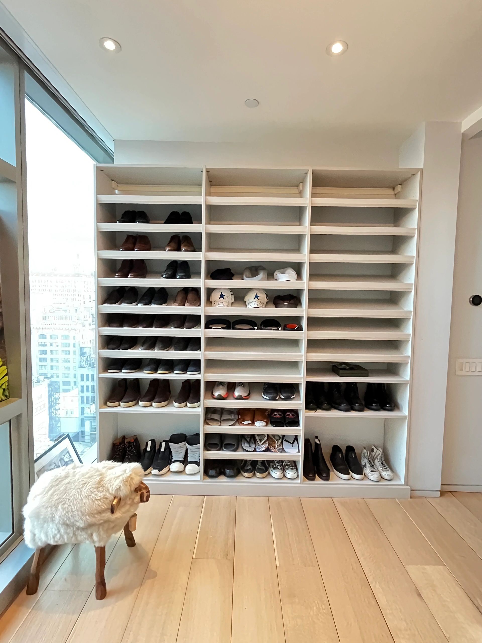 Modern shoe closet with floor-to-ceiling white shelving